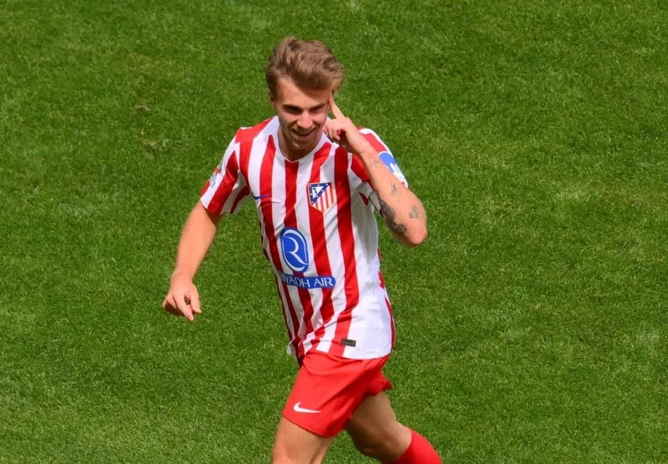 A photo of the Atletico Madrid team celebrating a goal, showcasing the players' emotions and teamwork.