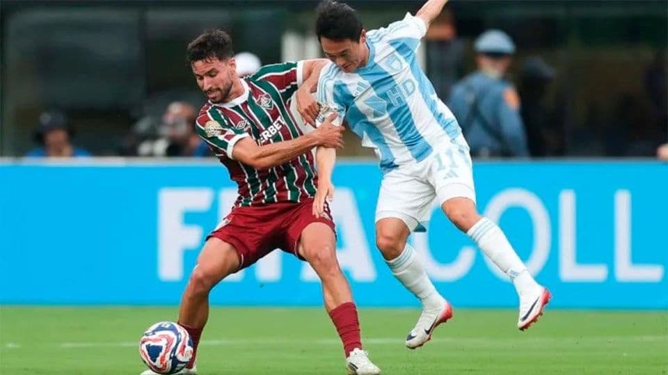 Action shot of Jhon Arias scoring a goal for Fluminense, with the Ulsan Hyundai goalkeeper and defenders reacting.