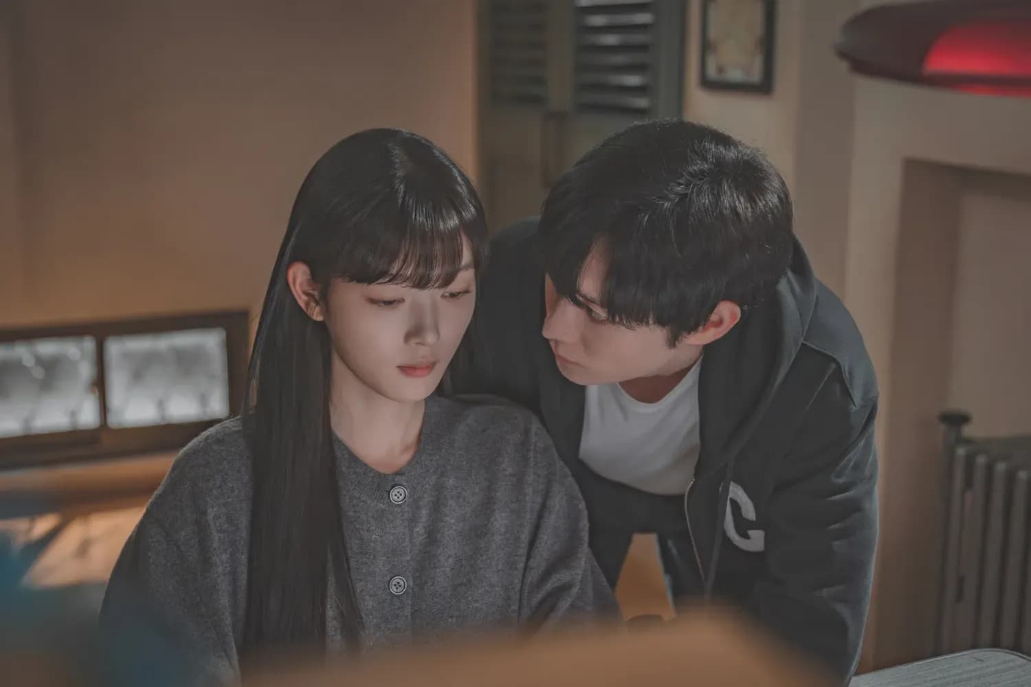 Ah Jin (Kim Yoo Jung) tập trung nhìn vào máy tính, gợi ý về sự thông minh và mưu lược trong các tình huống phức tạp.