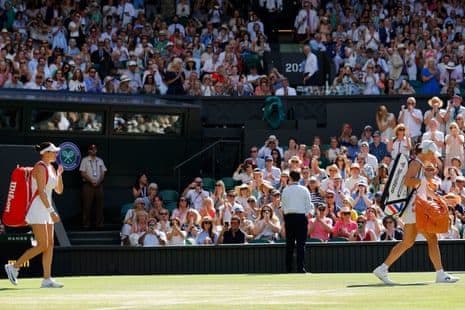 Amanda Anisimova và Iga Swiatek bước ra sân Trung tâm trước trận chung kết Wimbledon 2025.