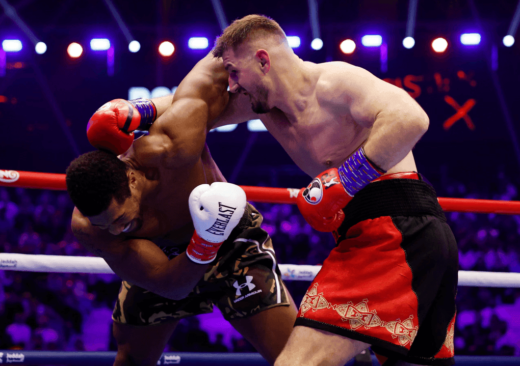 Anthony Joshua bị đối thủ Kristian Prenga đánh trúng, thể hiện sự chật vật và áp lực tâm lý trong trận đấu trở lại.