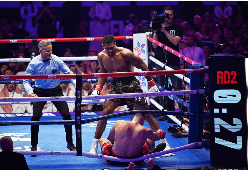 Anthony Joshua đứng trên võ đài sau khi hạ knock-out đối thủ, minh chứng cho bản lĩnh và ý chí chiến thắng.