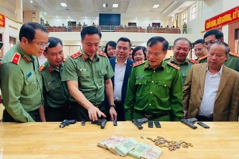Bộ trưởng Lương Tam Quang và các lãnh đạo công an kiểm tra tang vật, vũ khí thu giữ từ vụ cướp ngân hàng Gia Lai, thể hiện dấu ấn lãnh đạo.