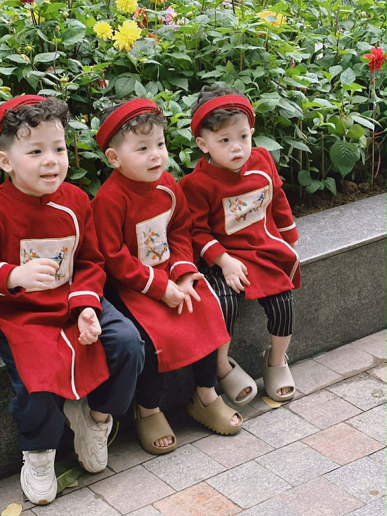 Ba em bé mặc áo dài đỏ truyền thống vui vẻ đón Tết.