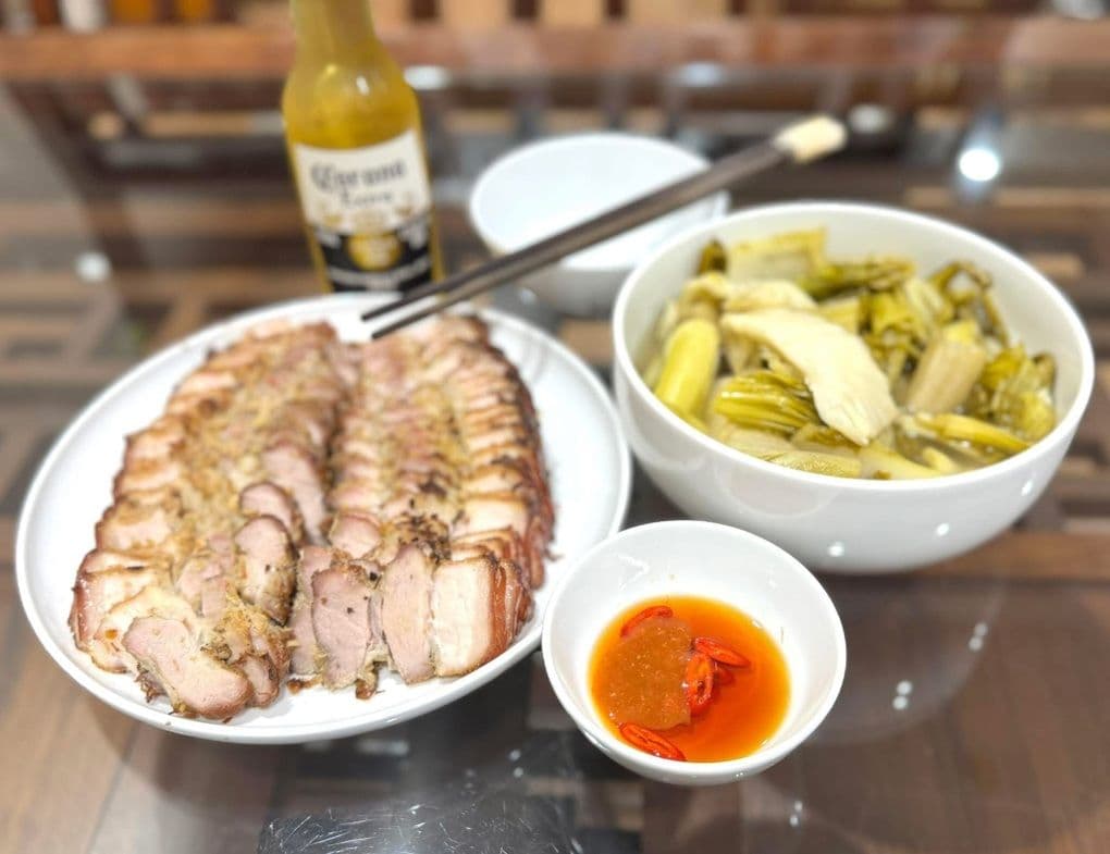 Bữa ăn gia đình với đĩa thịt một nắng thái lát, bát dưa cải muối và nước chấm ớt.