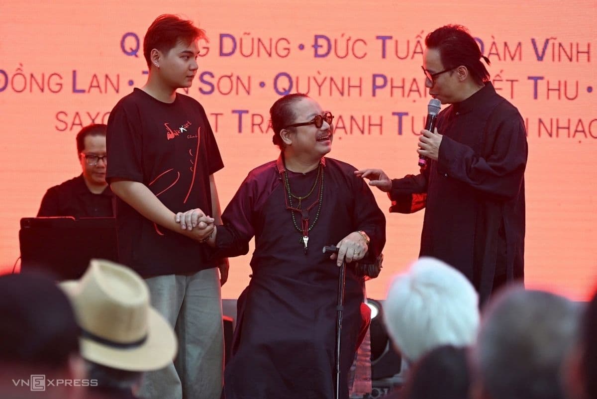 Ba nghệ sĩ trên sân khấu, một người lớn tuổi ngồi, hai người trẻ hơn đứng, thể hiện sự tiếp nối di sản âm nhạc Trịnh Công Sơn qua các thế hệ