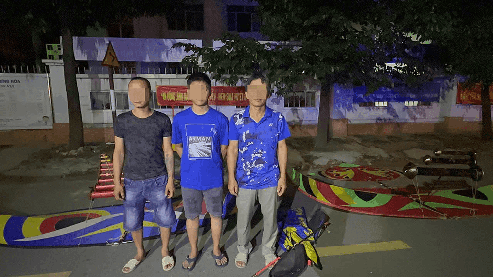 Ba người đàn ông đứng cạnh những chiếc diều sáo cỡ lớn có đèn chớp vào ban đêm, minh họa vụ việc vi phạm quy định không phận và trách nhiệm pháp lý.