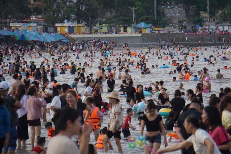 Bãi biển Đồ Sơn đông nghịt du khách đang tắm biển và vui chơi, minh họa áp lực lên hạ tầng du lịch Hải Phòng.