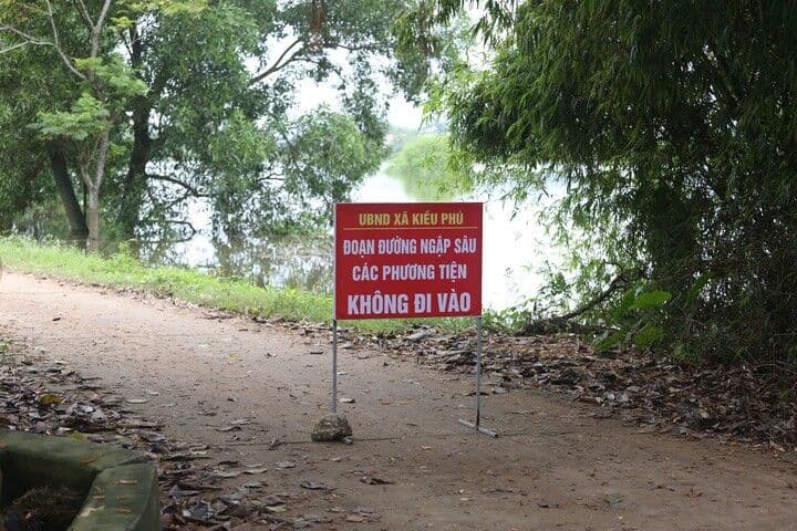 Biển cảnh báo 'Đoạn đường ngập sâu, các phương tiện không đi vào' trên tuyến đường bị ảnh hưởng bởi lũ lụt, nhấn mạnh yêu cầu xây dựng hạ tầng kiên cường