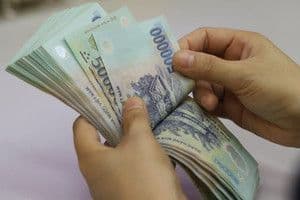 Bàn tay đang đếm tiền, tượng trưng cho nguồn thu ngân sách địa phương.