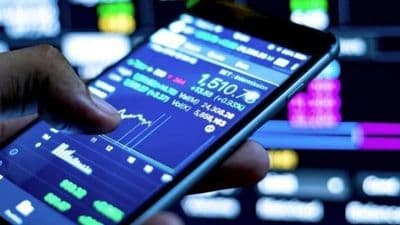 Bàn tay đang thao tác trên ứng dụng chứng khoán trên điện thoại, minh họa việc lướt sóng thông tin trong kỷ nguyên số.