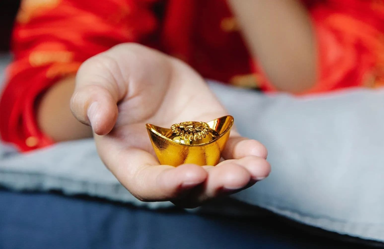 Bàn tay cầm thỏi vàng, tượng trưng cho tài lộc và sự thịnh vượng theo âm lịch.