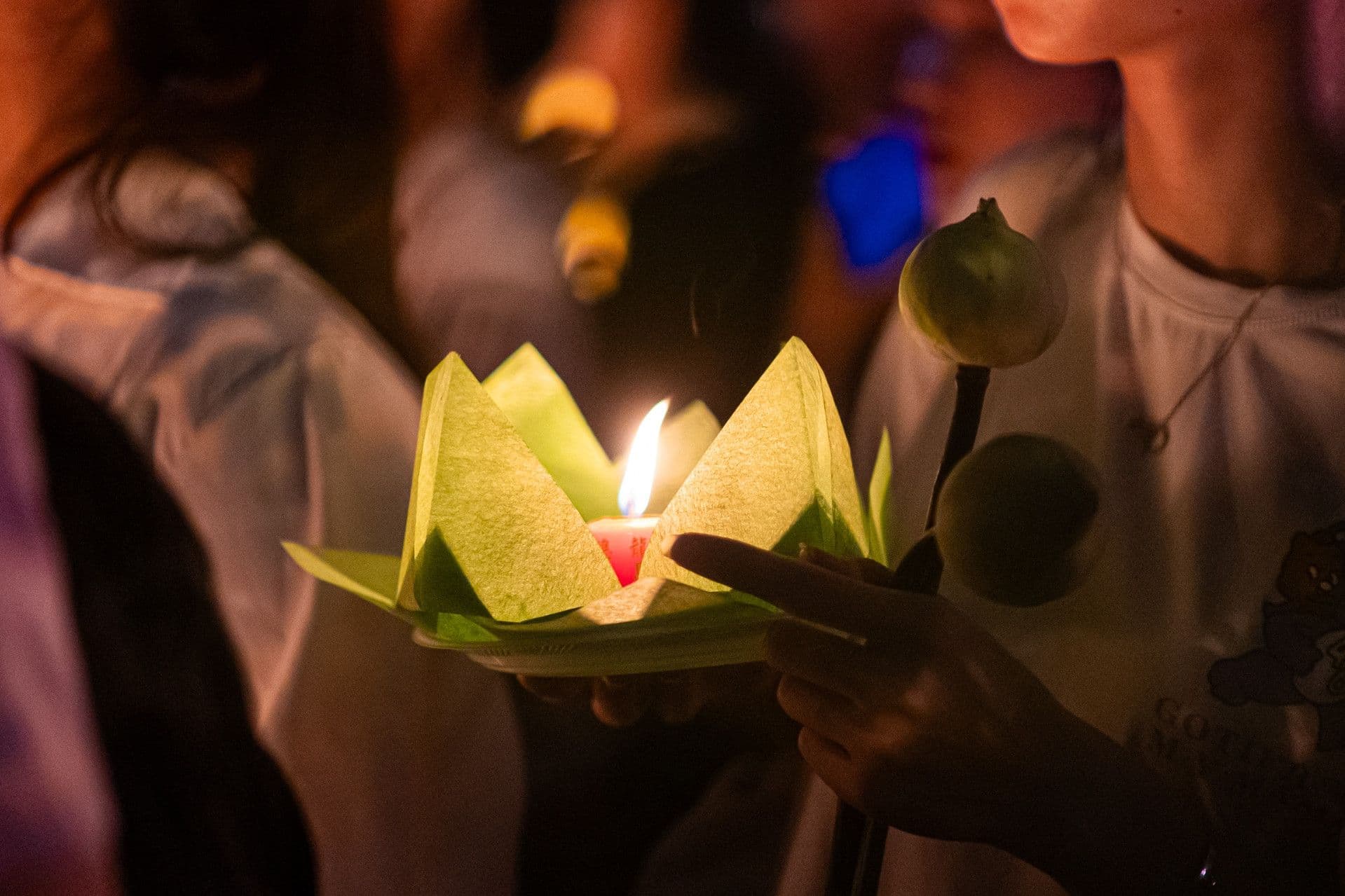 Bàn tay nâng niu ngọn nến lung linh hình hoa sen, biểu tượng của sự tĩnh tại và lòng thành kính trong nghi thức thờ cúng, mang lại an nhiên tinh thần.