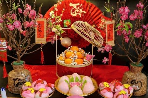 Bàn thờ cúng ông Công ông Táo trang trọng với hoa, quả và các vật phẩm thờ cúng