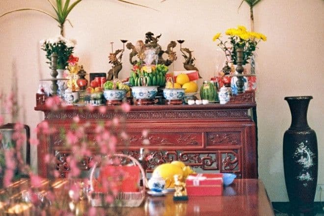 Bàn thờ gia tiên được trang hoàng trang trọng với mâm ngũ quả và hoa tươi để cúng ông Công ông Táo