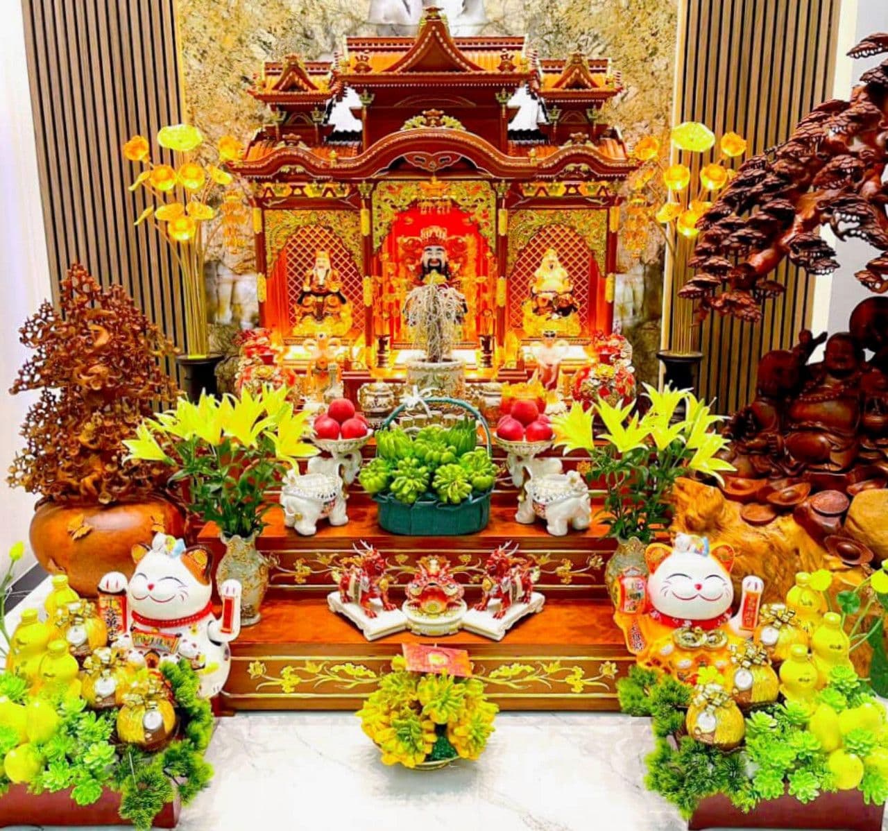 Bàn thờ Thần Tài được bài trí trang trọng với đầy đủ lễ vật, hoa tươi và tượng mèo thần tài, thể hiện lòng thành kính trong ngày Vía Thần Tài.