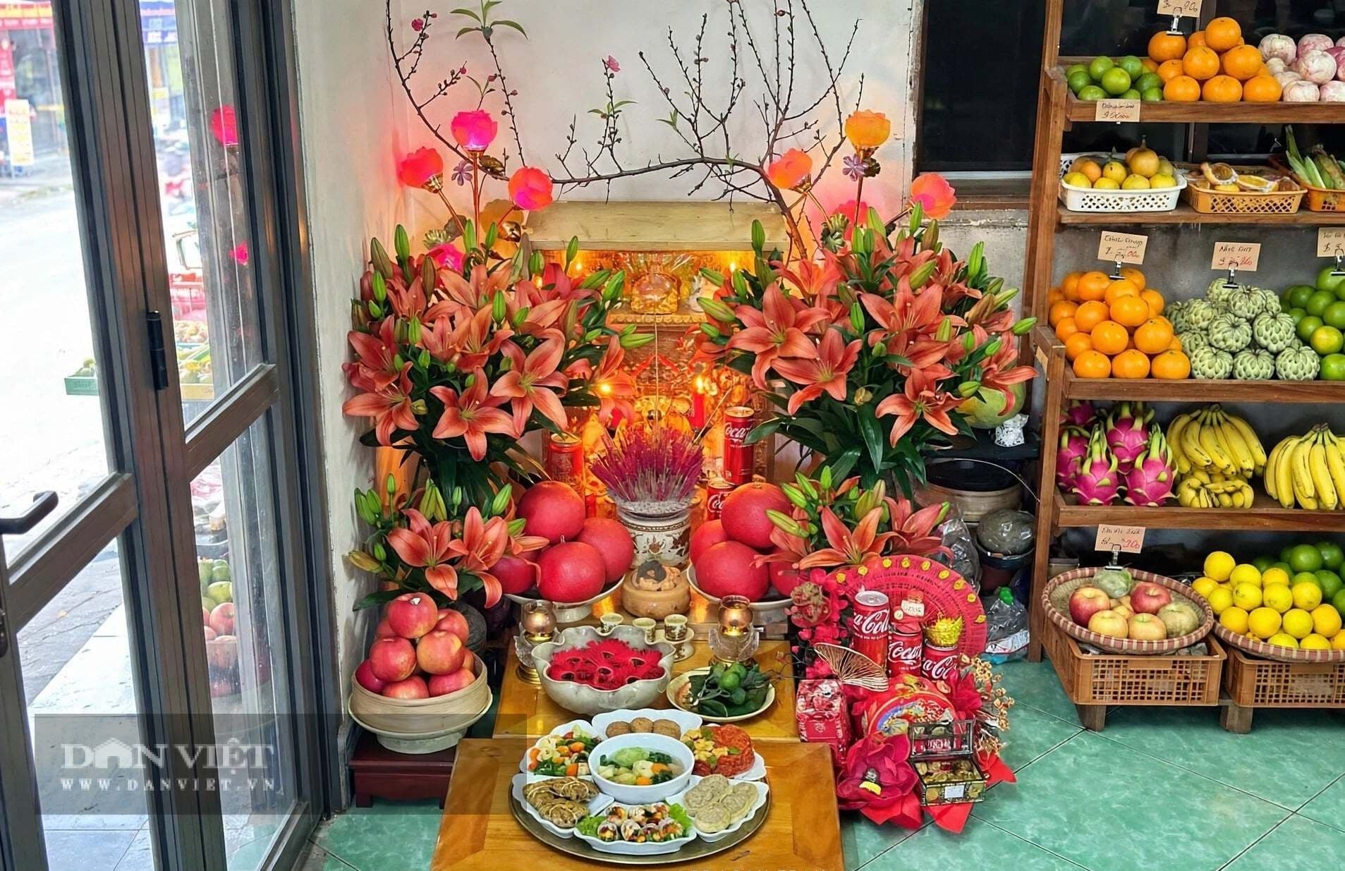 Bàn thờ Thần Tài được bày biện trang trọng với hoa tươi, trái cây và các lễ vật, thể hiện lòng thành kính cầu mong tài lộc, bình an cho công việc kinh doanh.
