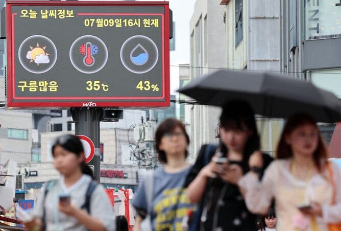 Bảng điện tử hiển thị nhiệt độ 35°C trên đường phố đô thị đông người, minh họa nắng nóng kỷ lục tại các thành phố.