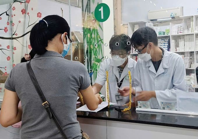 Bệnh nhân nhận thuốc tại quầy dược bệnh viện, minh họa quyền lợi BHYT cho bệnh hiểm nghèo.