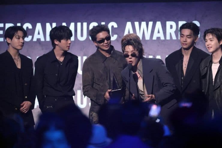 BTS nhận giải Artist of the Year trên sân khấu American Music Awards, tượng trưng cho sức ảnh hưởng toàn cầu của nhóm.