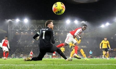 Bukayo Saka của Arsenal đánh đầu ghi bàn mở tỷ số vào lưới thủ môn Jose Sa của Wolves trong trận đấu dưới tuyết.