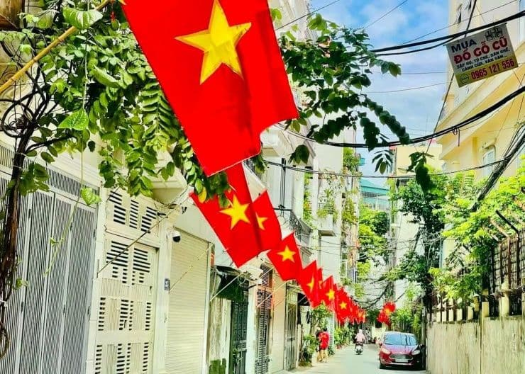 Cờ đỏ sao vàng Việt Nam treo dọc con phố nhỏ, biểu tượng cho kỳ nghỉ lễ Giỗ Tổ Hùng Vương và các ngày lễ lớn.
