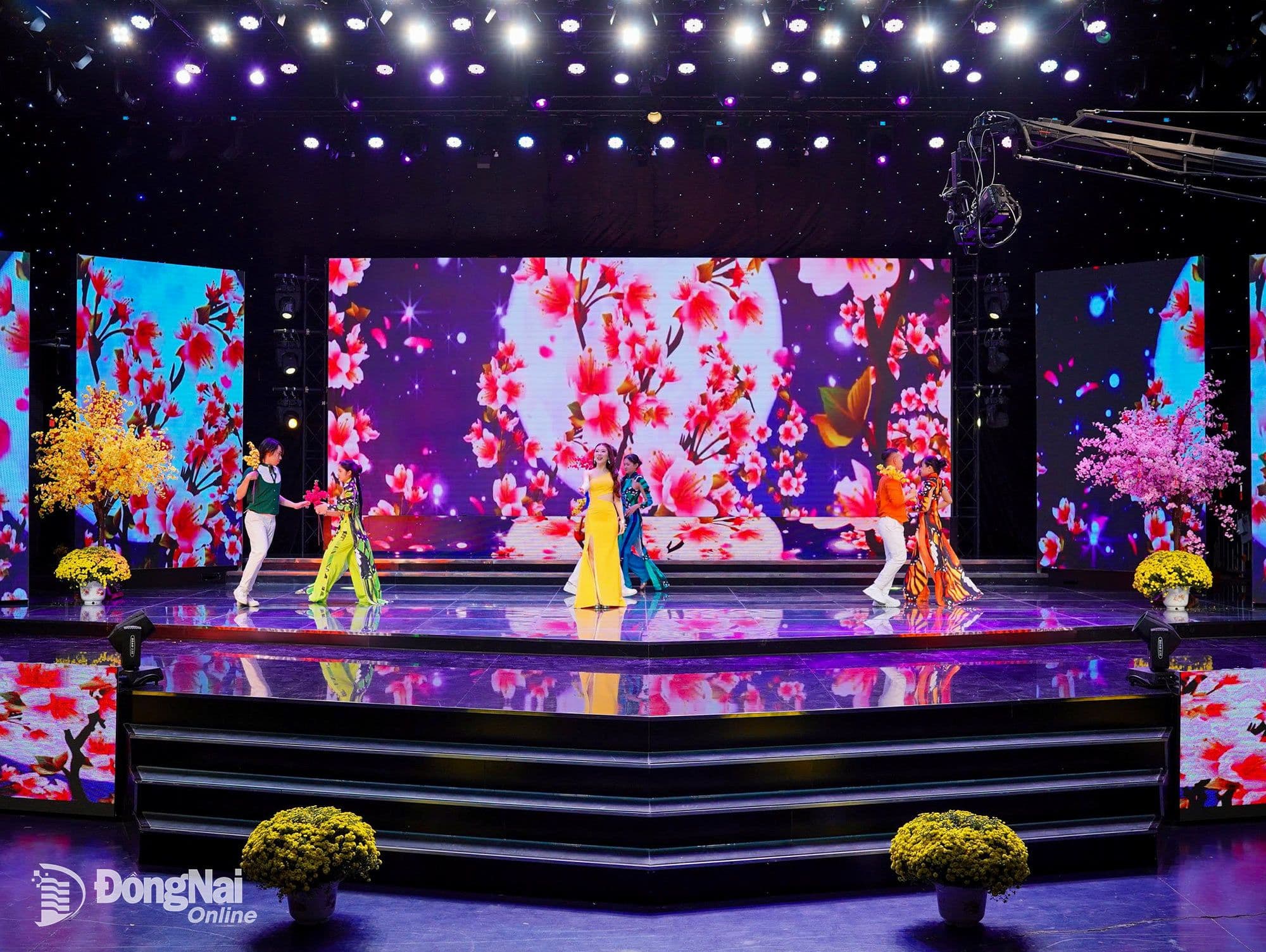 Ca sĩ Khải Vy biểu diễn ca khúc "Điệp khúc mùa xuân" trên sân khấu rực rỡ, tượng trưng cho sự khởi đầu năm mới tươi sáng.