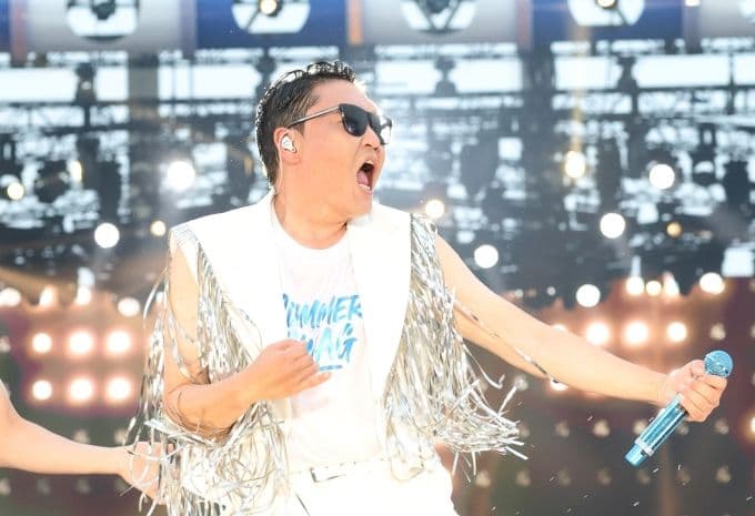 Ca sĩ PSY biểu diễn trên sân khấu, thể hiện năng lượng và danh tiếng toàn cầu của anh.