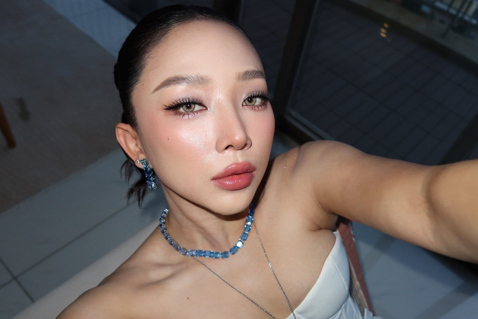 Ca sĩ Tóc Tiên với gương mặt trang điểm kỹ lưỡng, nhìn thẳng vào ống kính, đại diện cho hình ảnh người nổi tiếng trong thời đại số