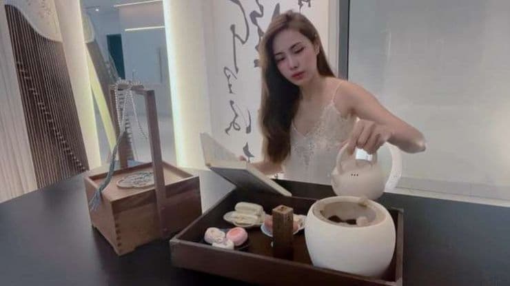 Ca sĩ Thủy Tiên nhâm nhi trà và đọc sách trong không gian biệt thự, tượng trưng cho khát vọng an yên và cuộc sống bình thường mới.