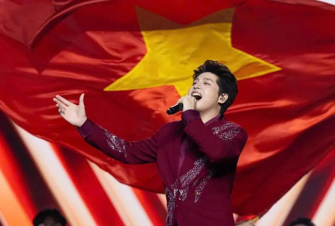 Ca sĩ Noo Phước Thịnh trình diễn trên sân khấu trước lá cờ Tổ quốc