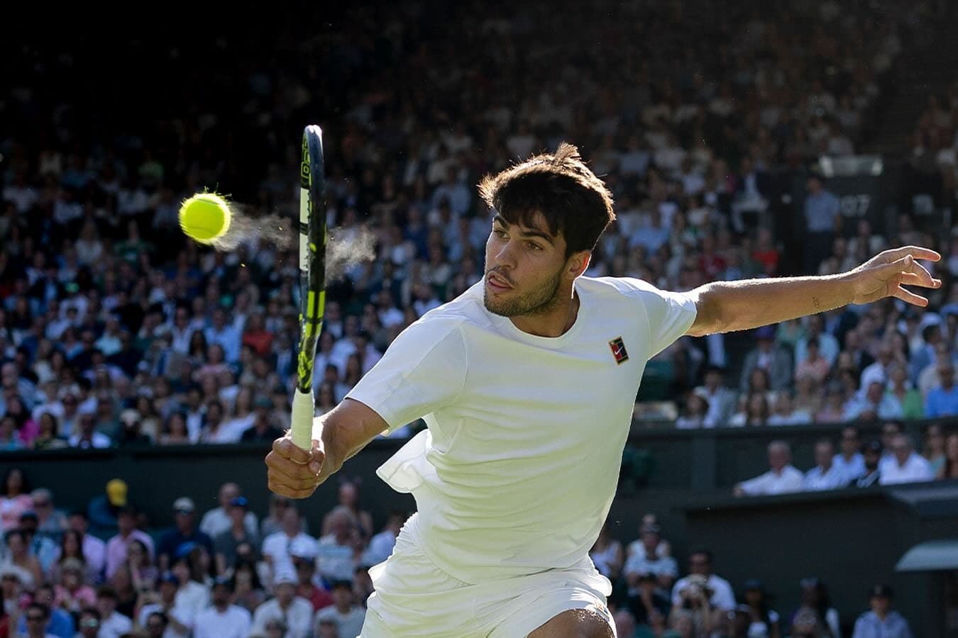 Carlos Alcaraz thực hiện cú đánh mạnh mẽ trên sân cỏ Wimbledon 2025, minh chứng cho phong độ hủy diệt của đương kim vô địch.