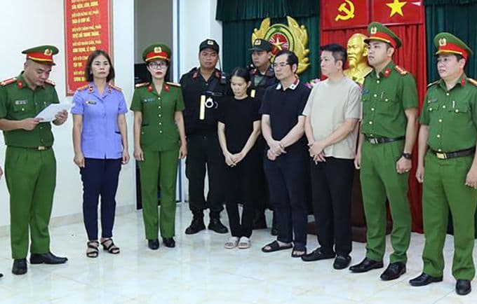Các bị can, bao gồm chồng Đoàn Di Băng, nghe công an đọc lệnh bắt trong vụ án buôn bán hàng giả mỹ phẩm.