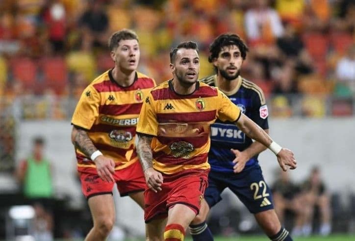 Các cầu thủ bóng đá đang thi đấu trên sân, thể hiện sự cạnh tranh.