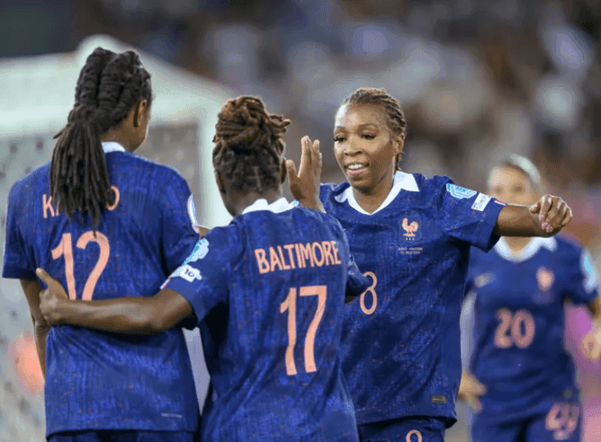 Các cầu thủ bóng đá nữ ăn mừng cùng nhau, nhấn mạnh sức mạnh tập thể.