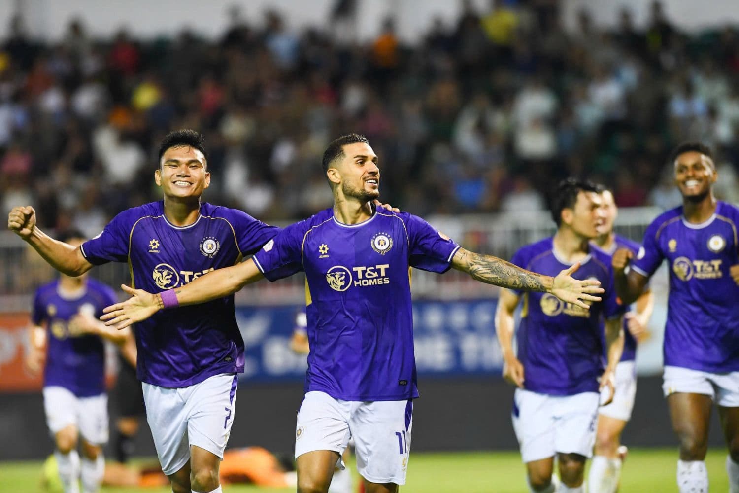 Các cầu thủ Hà Nội FC ăn mừng bàn thắng, tượng trưng cho trải nghiệm và niềm vui mà bóng đá mang lại cho khán giả.