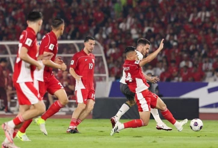 Các cầu thủ đội tuyển Indonesia trong trang phục áo đỏ thi đấu trên sân.