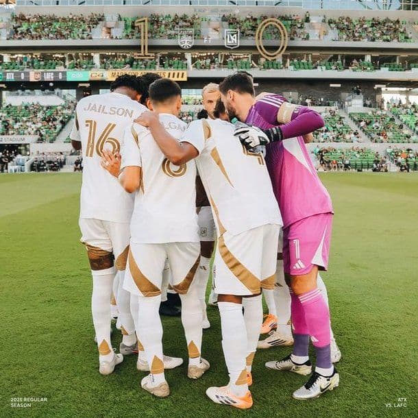 Các cầu thủ LAFC huddle trên sân với bảng tỷ số 1-0 nghiêng về đối thủ, phản ánh sự bế tắc sau bàn thua.