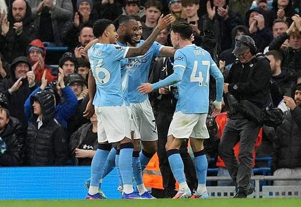 Các cầu thủ Man City ăn mừng bàn thắng cùng người hâm mộ, thể hiện niềm vui và tinh thần bóng đá Ngoại hạng Anh.