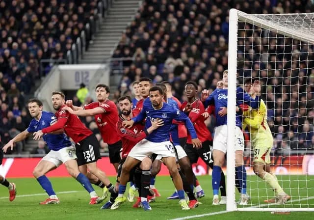 Các cầu thủ Manchester United và Everton tranh chấp quyết liệt trong vòng cấm, tượng trưng cho sự vật lộn tìm kiếm bản sắc.