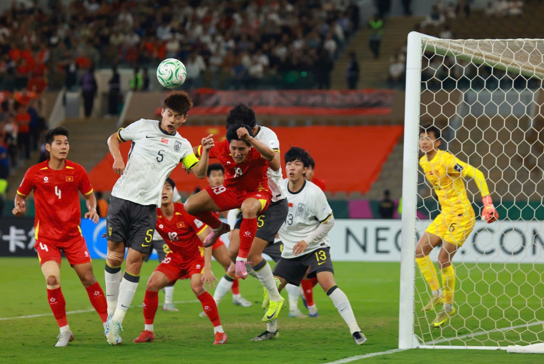 Các cầu thủ U23 Việt Nam và U23 Trung Quốc tranh chấp bóng trên không trong một pha phạt góc, thể hiện sự quyết liệt của trận đấu.