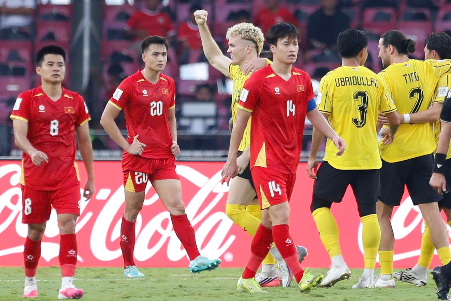 Các cầu thủ Việt Nam thất vọng sau trận thua 0-1 trước Malaysia tại FIFA ASEAN Cup, trong khi một cầu thủ Malaysia ăn mừng chiến thắng.
