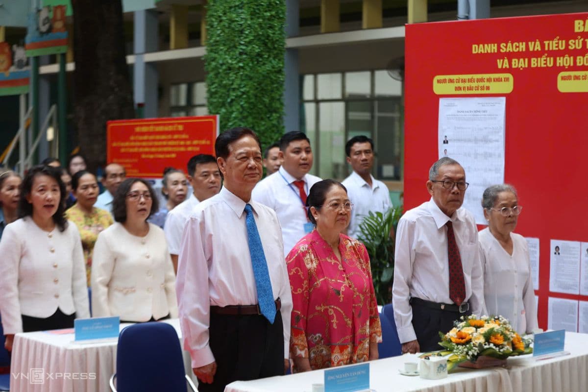 Các đại biểu và cử tri làm lễ chào cờ khai mạc tại điểm bầu cử, biểu tượng cho sự minh bạch và ý thức công dân.