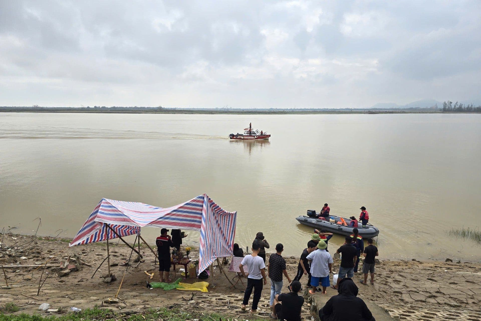 Các đội cứu hộ và người dân tập trung bên sông Lam, thể hiện sự đồng lòng trong tìm kiếm.