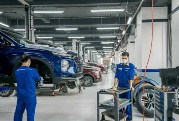 Các kỹ thuật viên đang làm việc trong xưởng dịch vụ ô tô, minh họa cho việc tăng thời gian bảo hành như một chiến lược định vị giá trị bền vững.
