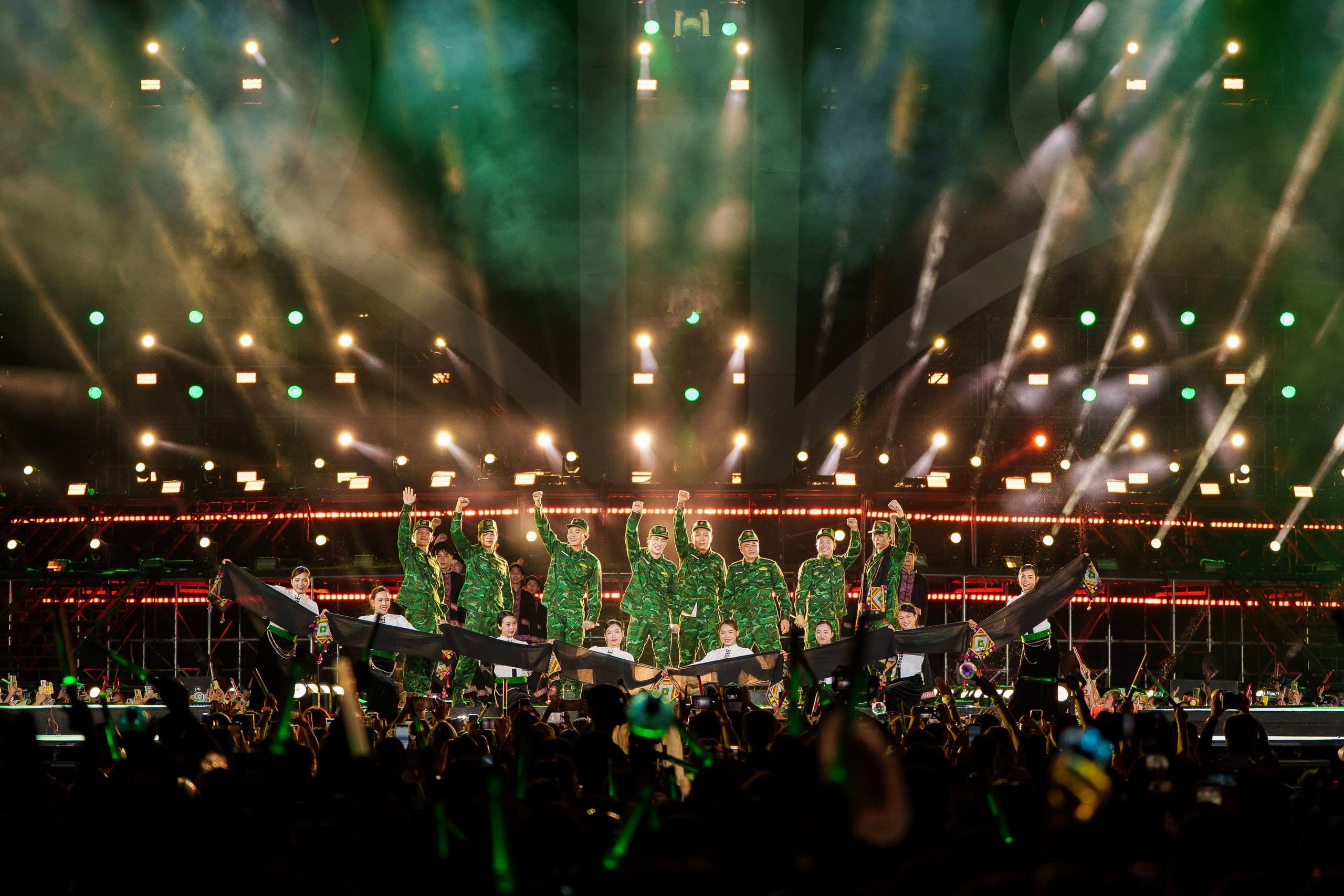 Các nghệ sĩ trong trang phục quân đội biểu diễn trên sân khấu, thể hiện tinh thần vượt chông gai.