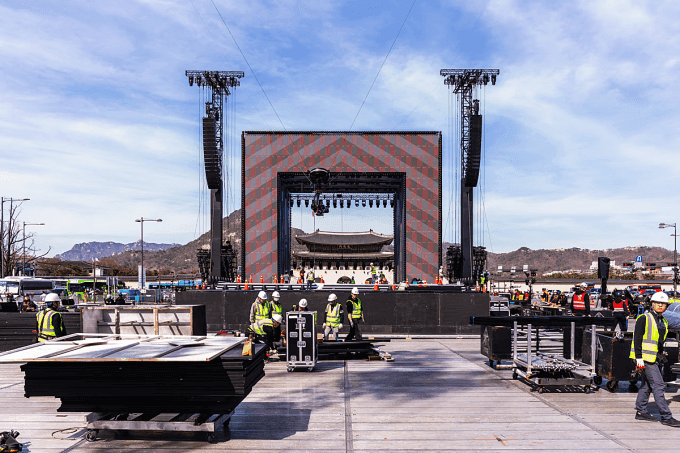 Các nhân viên đang dựng sân khấu hoành tráng cho buổi biểu diễn của BTS trước cung điện Gyeongbokgung, thể hiện quy mô và áp lực của sự kiện