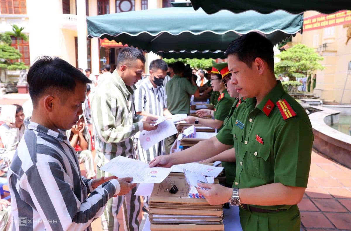 Các phạm nhân được đặc xá nhận giấy tờ và tài liệu từ cán bộ trại giam, chuẩn bị tái hòa nhập cộng đồng.