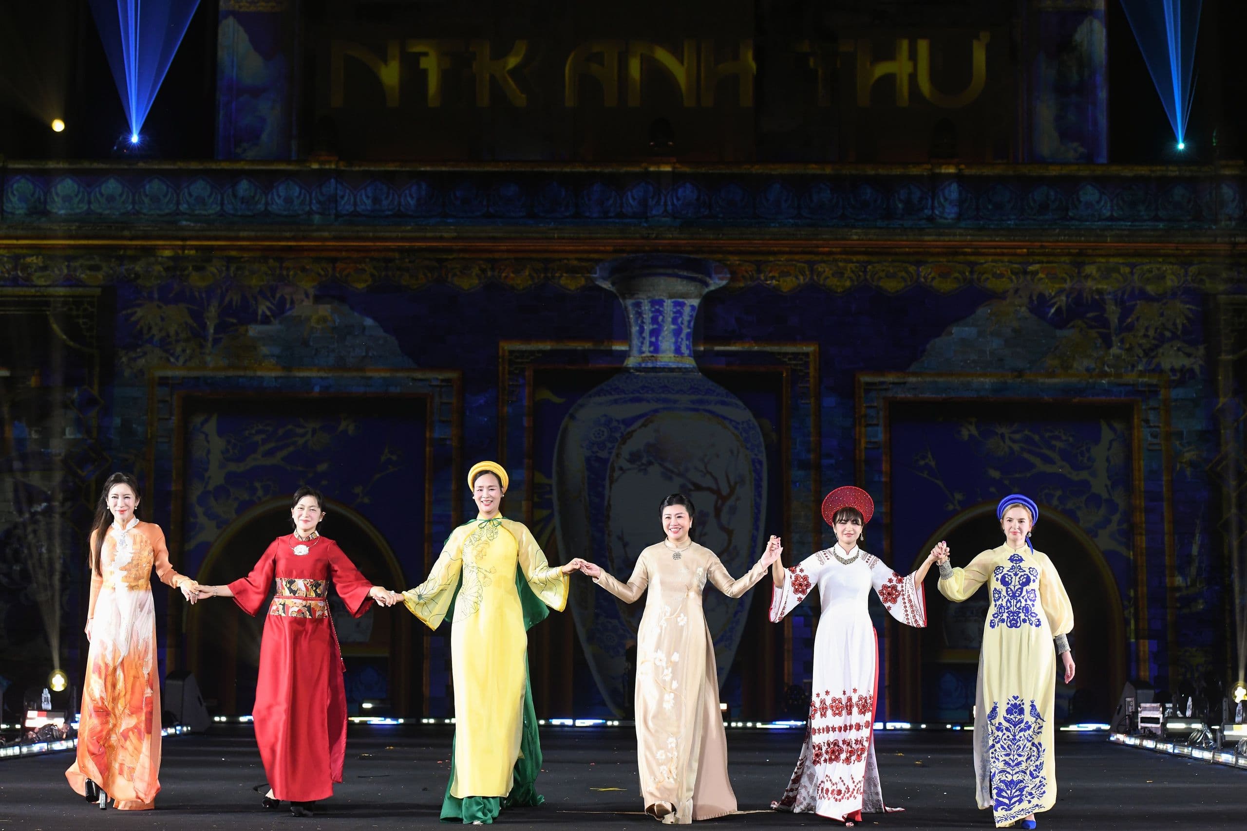 Các phu nhân đại sứ duyên dáng trong tà áo dài Việt Nam, tay trong tay thể hiện tình hữu nghị tại lễ khai mạc.