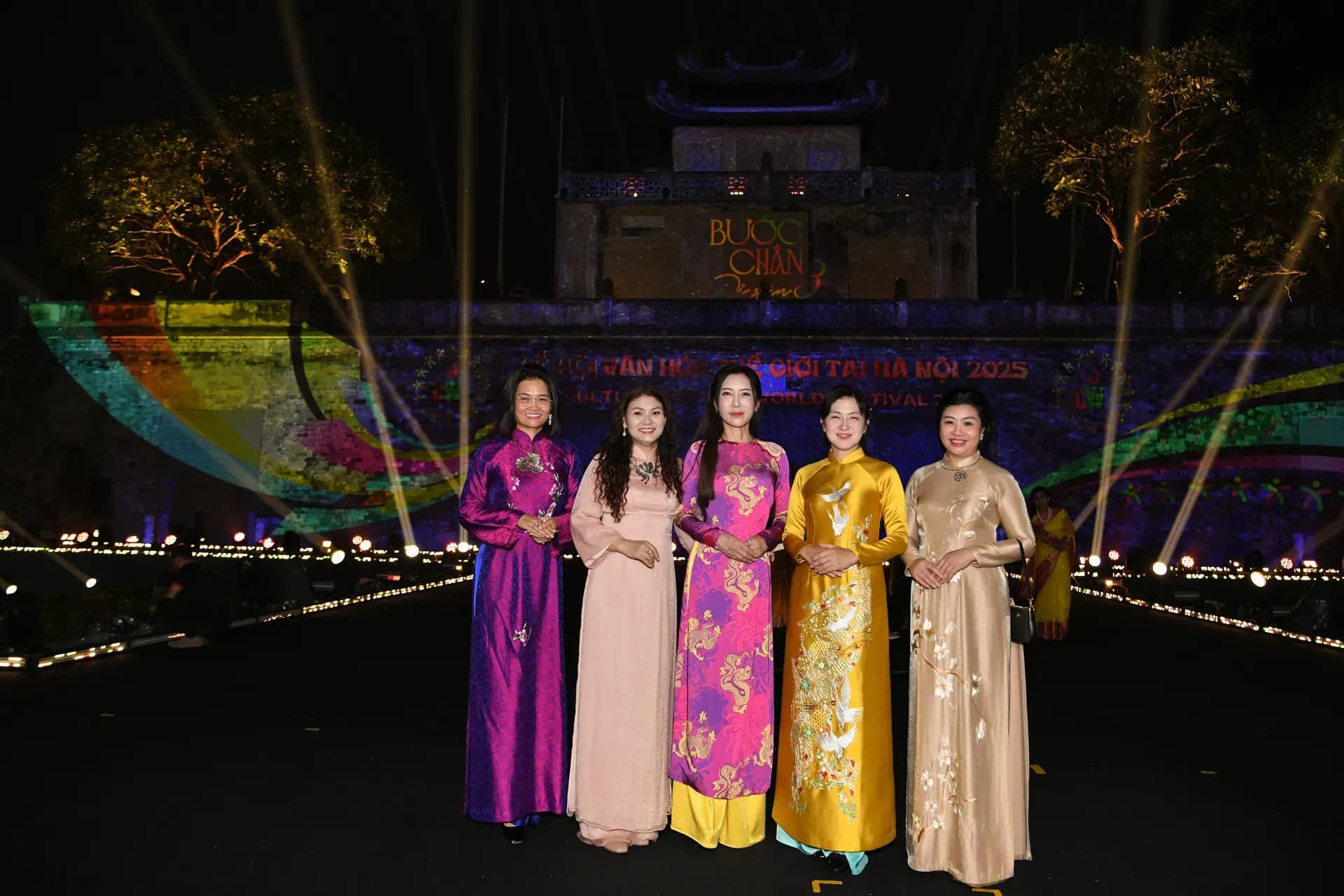 Các phu nhân đại sứ và khách mời chụp ảnh lưu niệm trước Hoàng thành Thăng Long, di sản lịch sử chứng kiến sự kiện văn hóa.